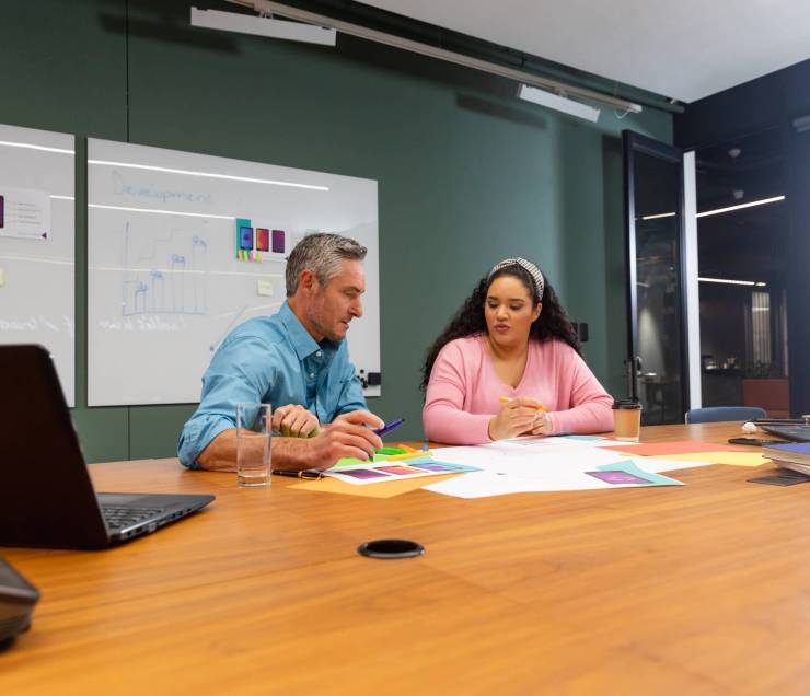 Multiracial businessman and businesswoman planning strategy in creative office. Unaltered, creative business, workplace, discussion, diversity, planning, meeting.